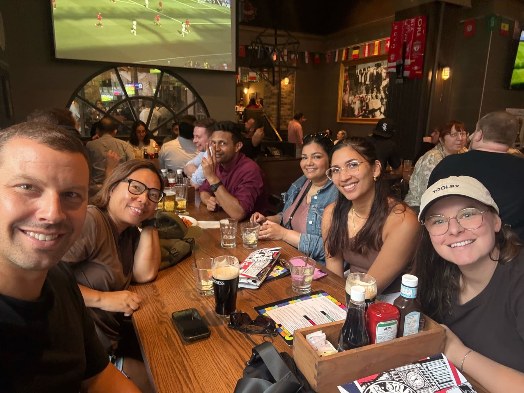 The team watching a match together at a pub after work