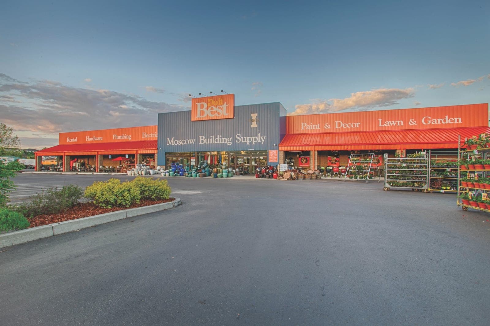 Moscow Building Supply's storefront at dusk, with the lawn and garden section stocked out front