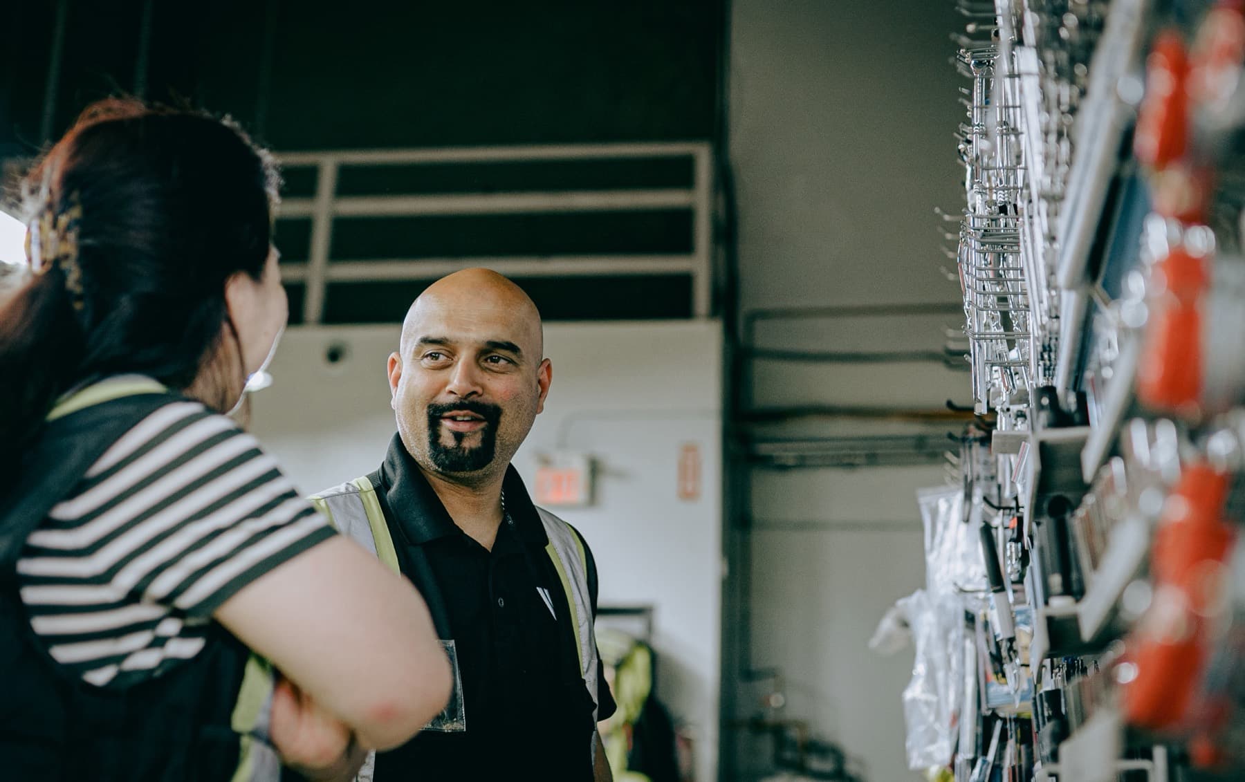 Two staff coordinating on a dealer's shop floor, one in hi-vis