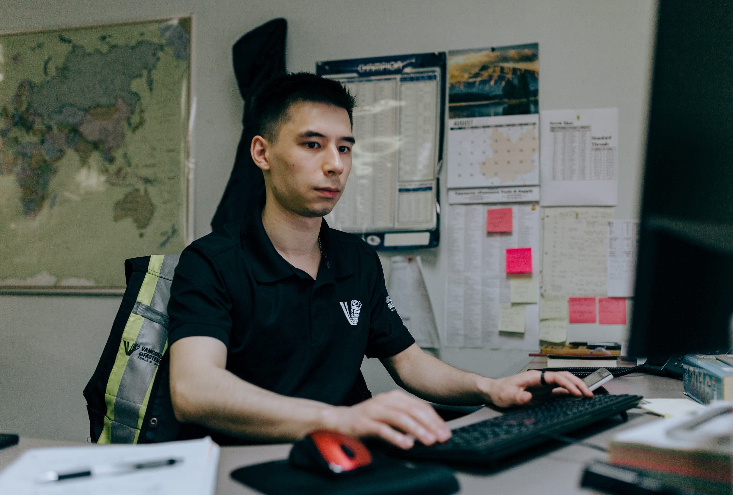 A dealer's back-office staff member at a desk, working an order on the computer